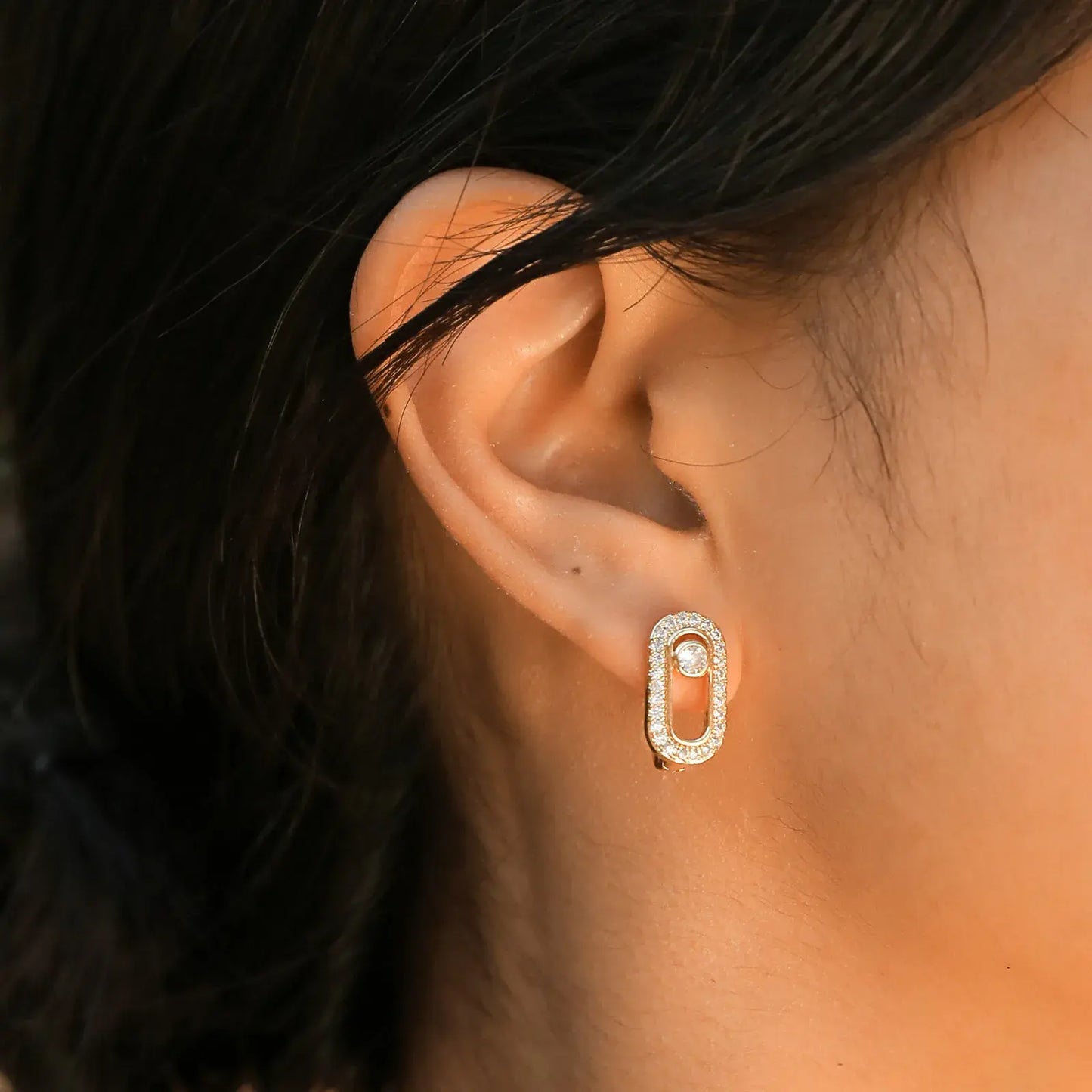 Geometric paper clip earrings on the right ear