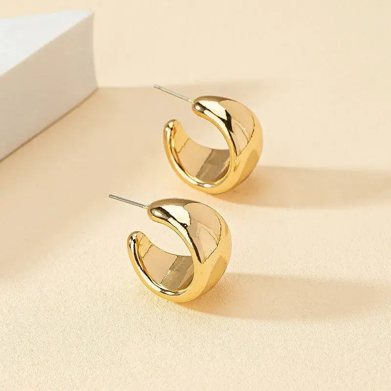 Stylish gold chunky hoop earrings for women, featuring a bold, shiny design that adds a modern touch to any outfit.