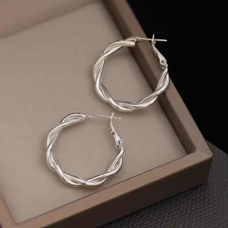 Elegant silver twisted hoop earrings for women, showcasing a stylish and timeless design perfect for everyday wear.